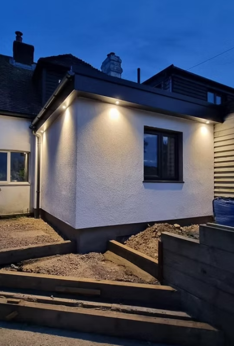 Single-storey extension with soffit lighting at dusk