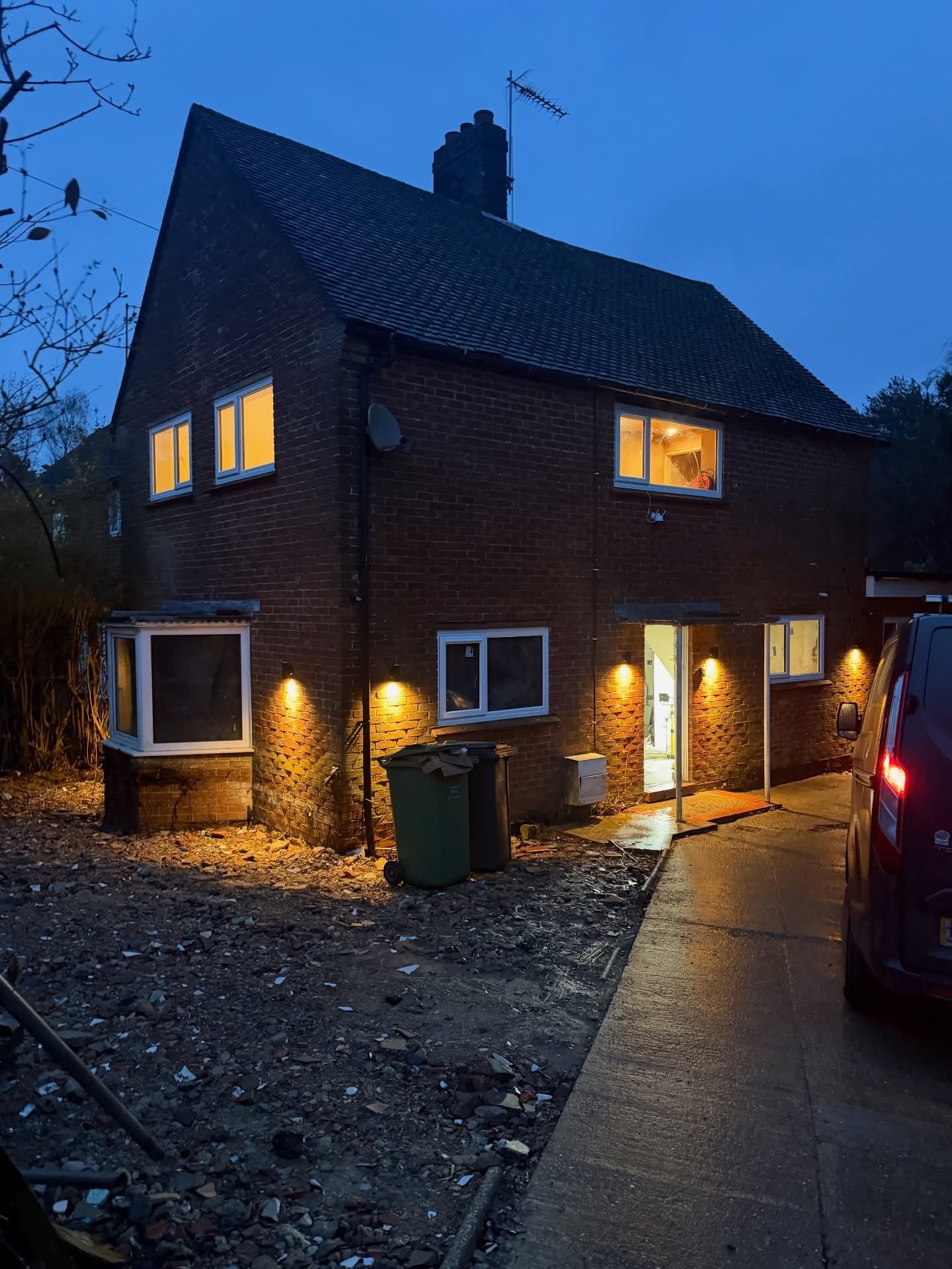 Exterior wall lights illuminating a brick house at dusk